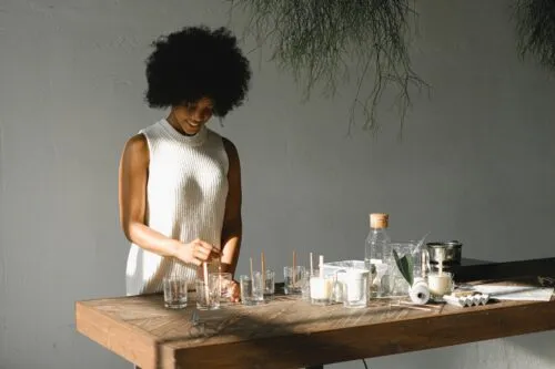 cheerful black woman making candles