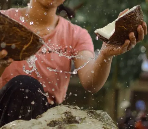 photo of woman cracking coconut shells