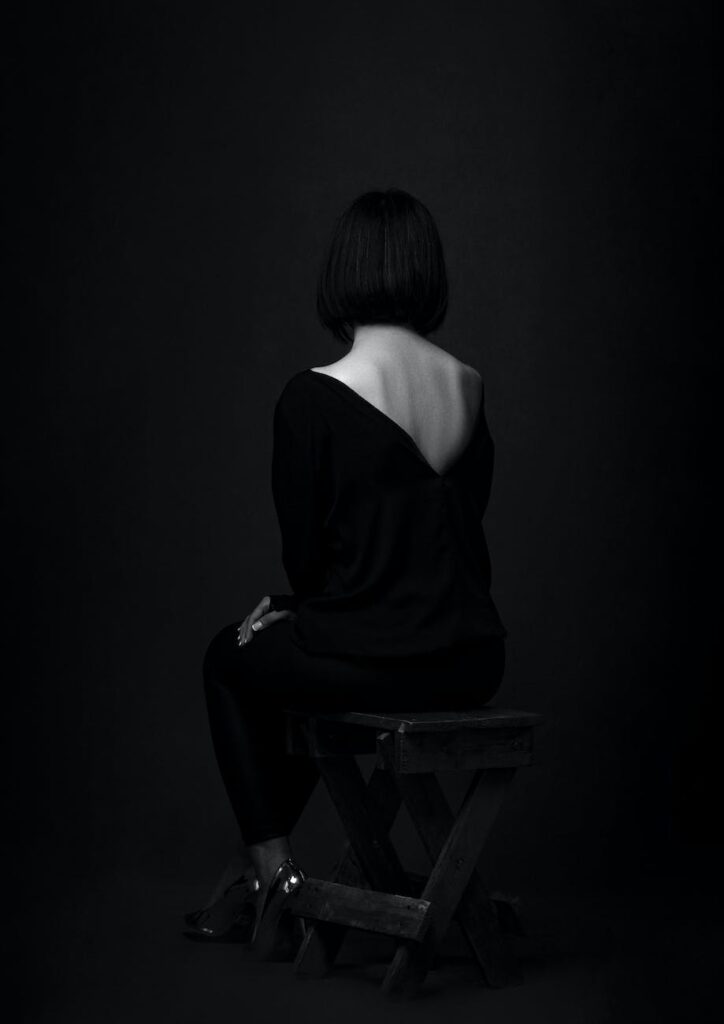 artistic photograph of sitting woman in black shirt