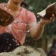 photo of woman cracking coconut shells